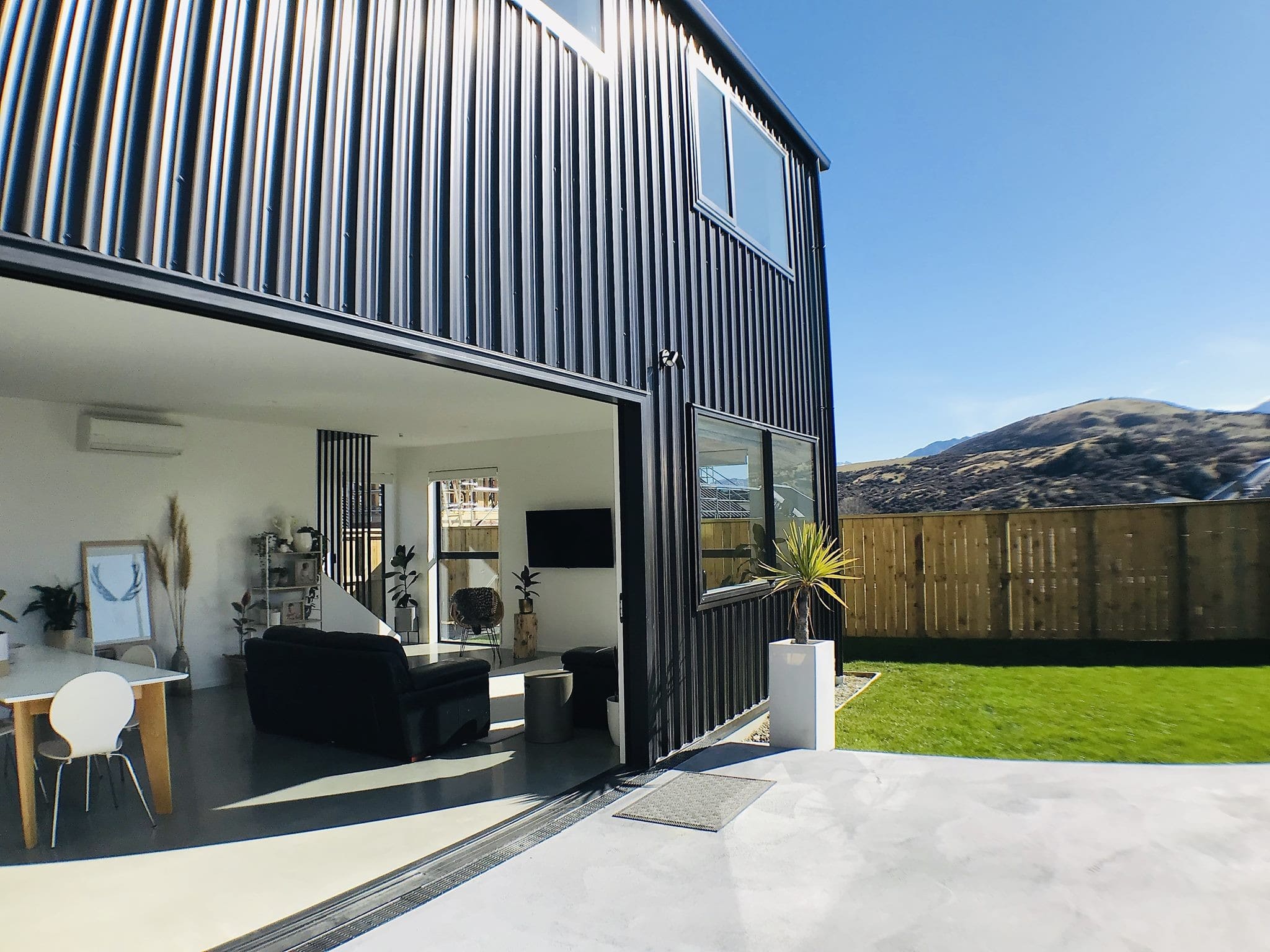 Sliding doors opened the full width of the living room onto the lawn, with hills beyond