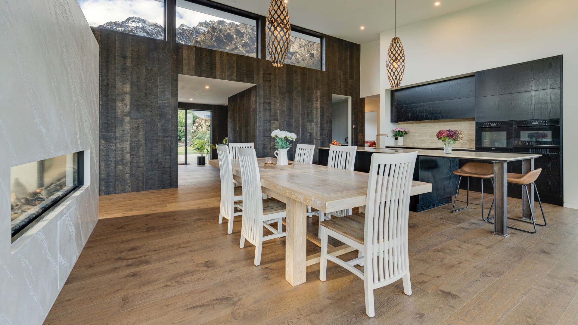 Dining table beside a long gas fire, opening to the terrace
