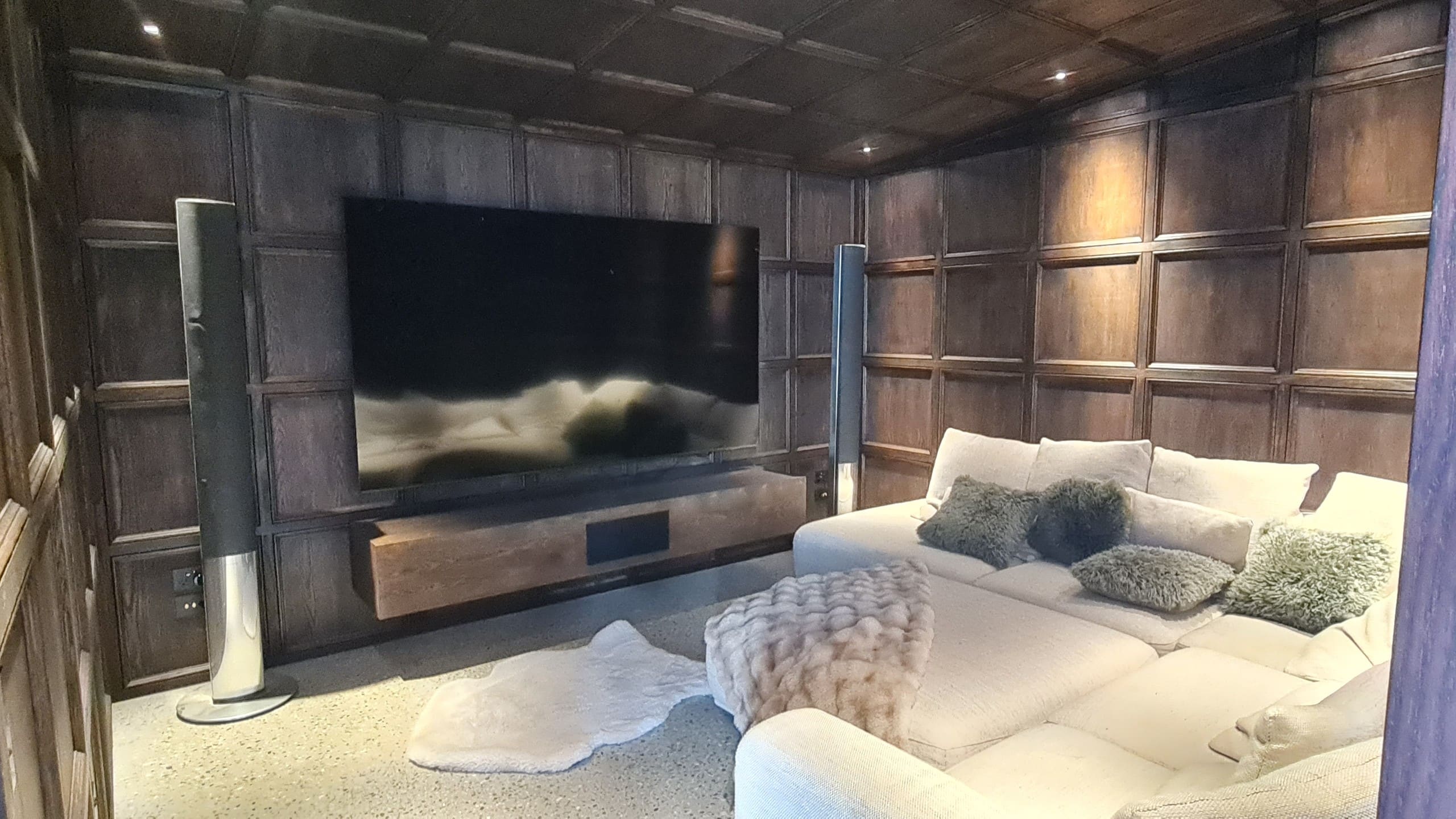 Oak-panelled living room with a fire below the screen