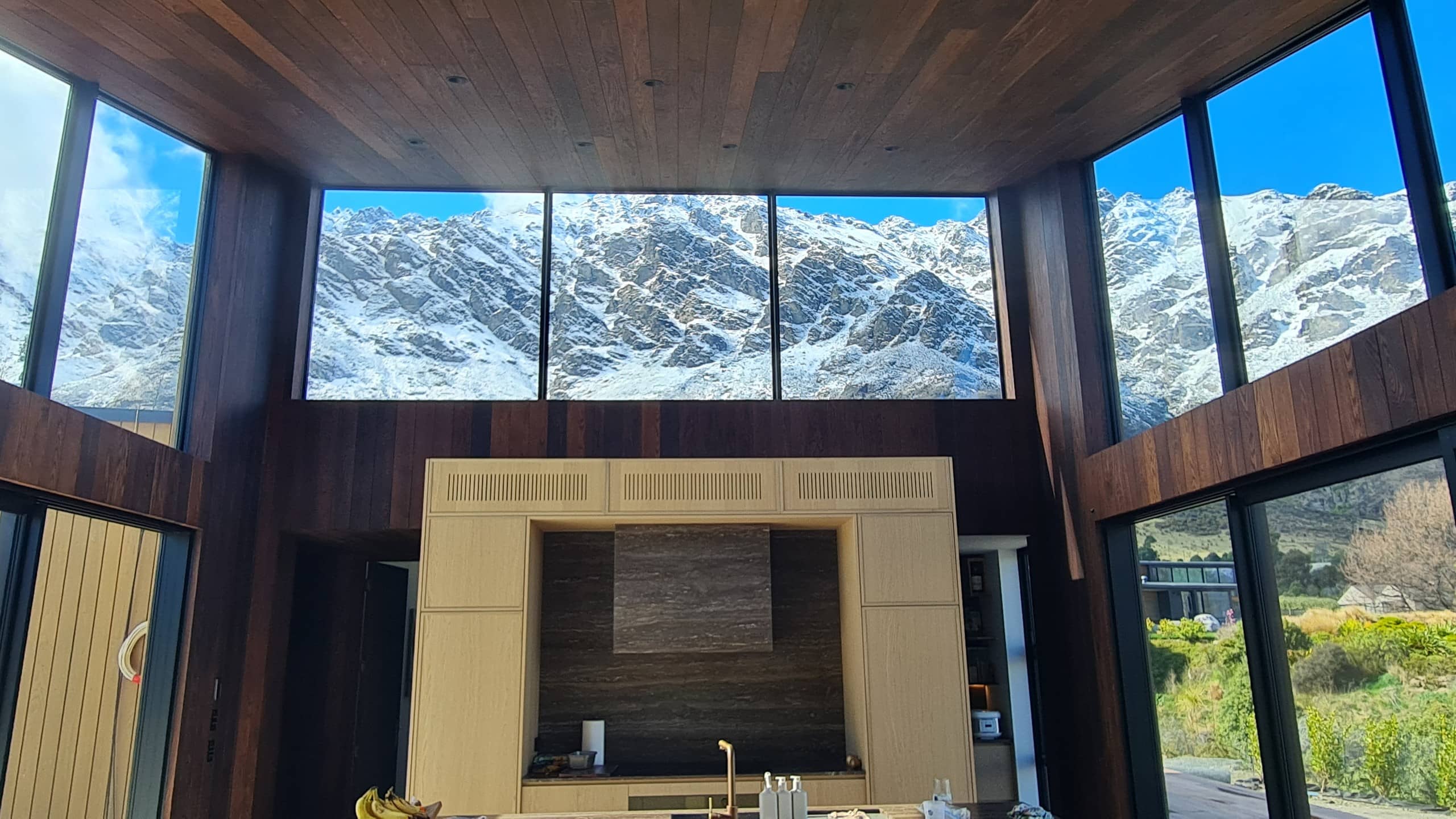 Living room under an oak ceiling, glazed on three sides to the Remarkables