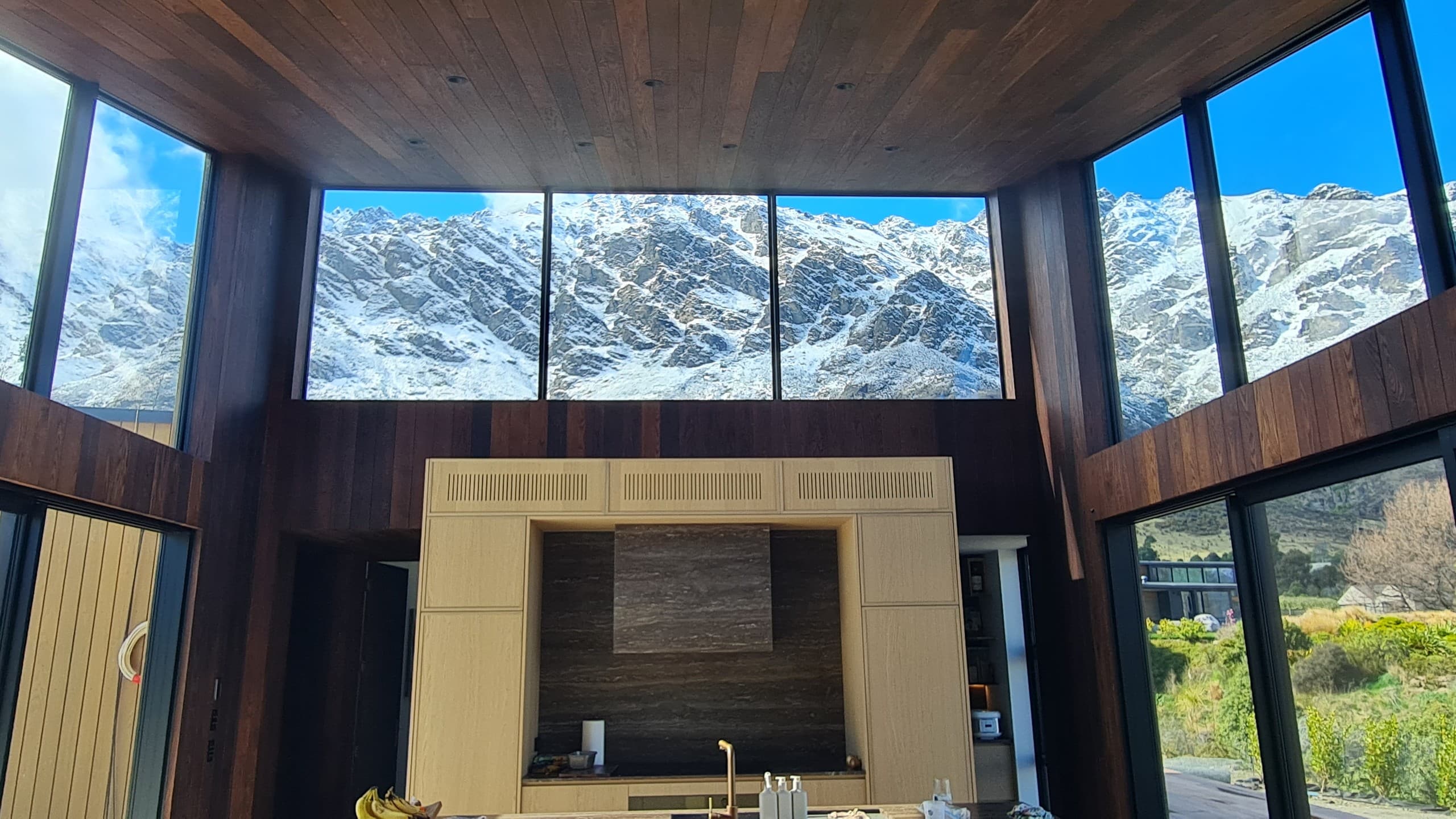 Living room under an oak ceiling, glazed on three sides to the Remarkables